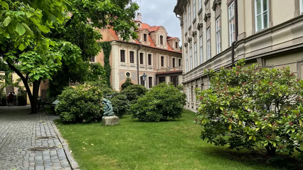 Зеленая трава и деревья перед коричневым бетонным зданием под дневным светом - городской парк и архитектурный контраст